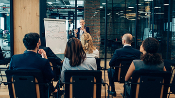 Woman giving a presentation to a room of people